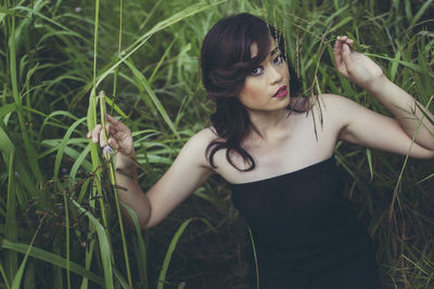 Portrait young woman standing on field