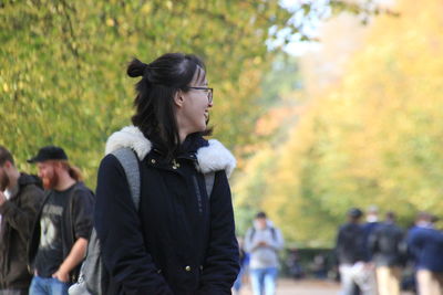 Full length of young woman walking in park during autumn