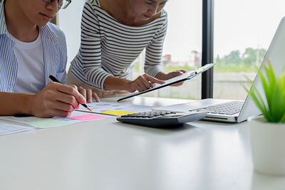 Midsection of man using laptop on table