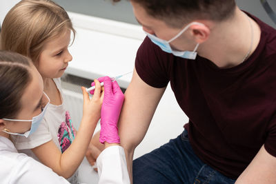 Side view of doctor examining patient at clinic