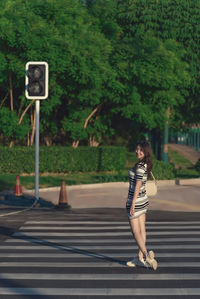 Portrait of young woman walking on road