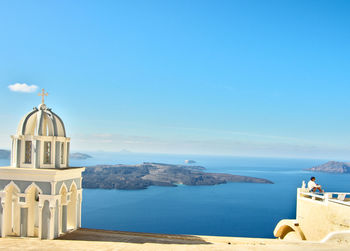 Built structure by sea against blue sky