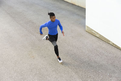 Determined young man running on footpath