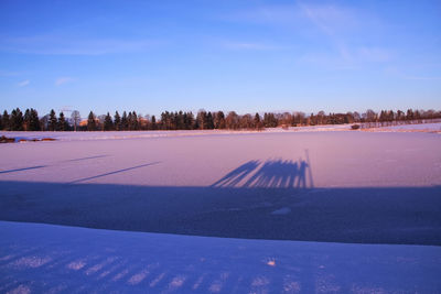 Scenic view of snow covered landscape against blue sky