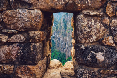 Mountain seen through window of old building at machu picchu