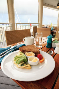 Egg white omelet with spinach, avocado slices and cheese along with wheat toast for breakfast