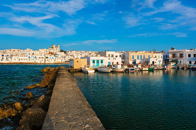 Canal amidst buildings in city against sky