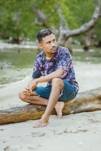 Young woman sitting on rock at beach