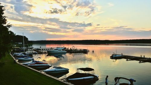 Boats in sea at sunset