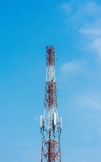 Low angle view of electricity pylon against blue sky