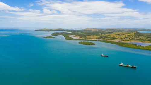 Cargo ships leaving sea harbour at sunny day, islands on background. tapal wharf, bohol, philippines