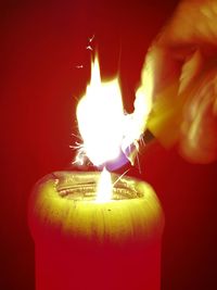 Close-up of lit candle in darkroom