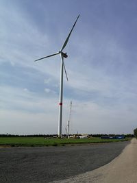 Low angle view of windmill on field against sky