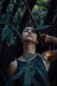 Portrait of woman looking up in forest