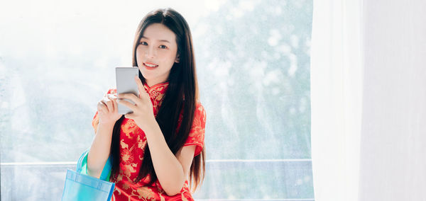 Portrait of young woman using mobile phone