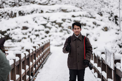 Portrait of young man standing in snow