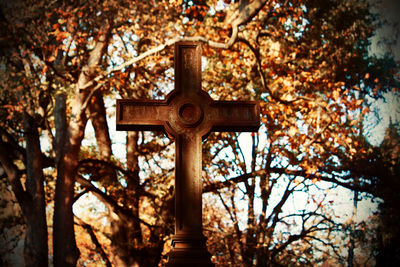 Low angle view of cross on tree against temple