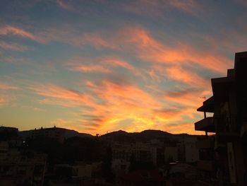 Houses against sky during sunset