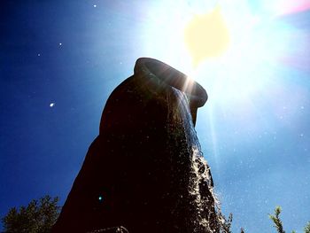 Low angle view of bright sun against sky on sunny day