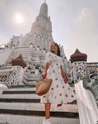 Young girl in a white dress in bangkok near wat arun.