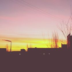 Low angle view of silhouette built structure against sky at sunset