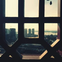 Close-up of cityscape against sky seen through window