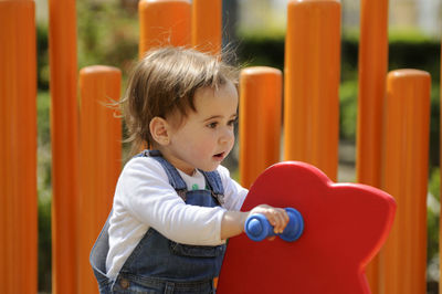 Cute boy playing at playground while looking away