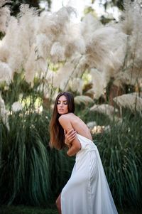 Portrait of woman standing against plants