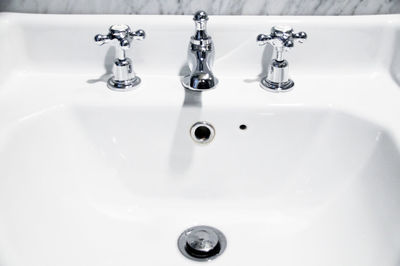 High angle view of faucets on sink in bathroom