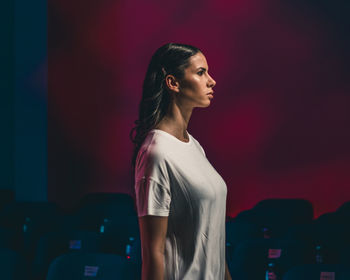 Young woman standing against wall