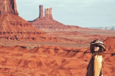 Portrait of woman wearing hat standing at desert