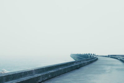 Bridge over sea against sky during foggy weather