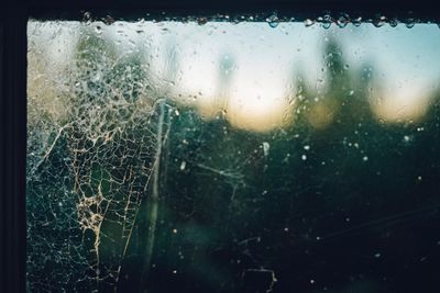 Close-up of wet glass window during rainy season