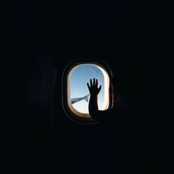 Silhouette girl looking through airplane window