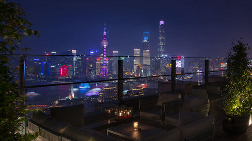 Illuminated modern buildings against sky at night