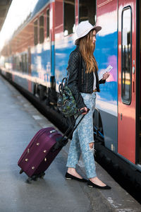 Woman standing by train at railroad station platform