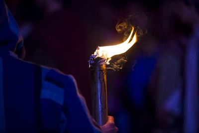 Cropped image of person holding flaming torch