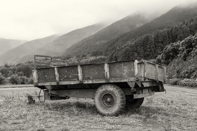 Vintage car on field by mountains against sky