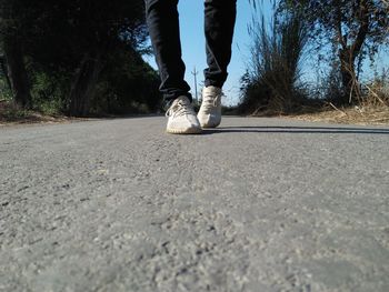 Low section of man standing on road