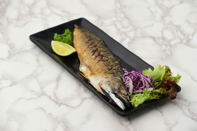 High angle view of fish in plate on table