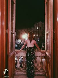 Rear view of woman standing at entrance of building