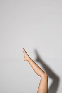 Low section of woman against white background