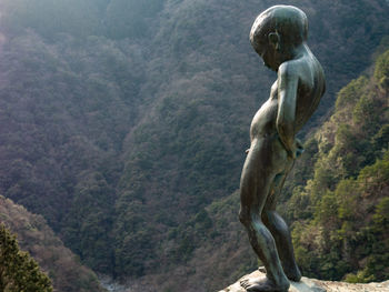 Statue against trees in forest