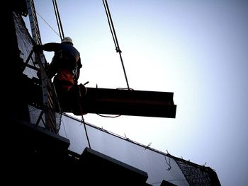 Low angle view of crane against sky