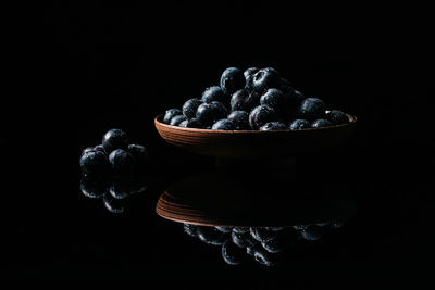 High angle view of berries in bowl against black background