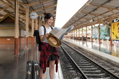 Rear view of woman standing on railroad station