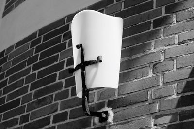Low angle view of electric lamp against wall