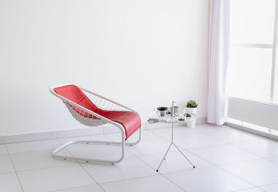 Minimal light and airy interior. white living room with red leather chair and coffee table