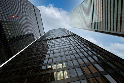 Low angle view of modern glass building against sky