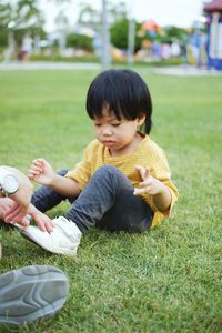 Portrait of boy playing with ball on grass